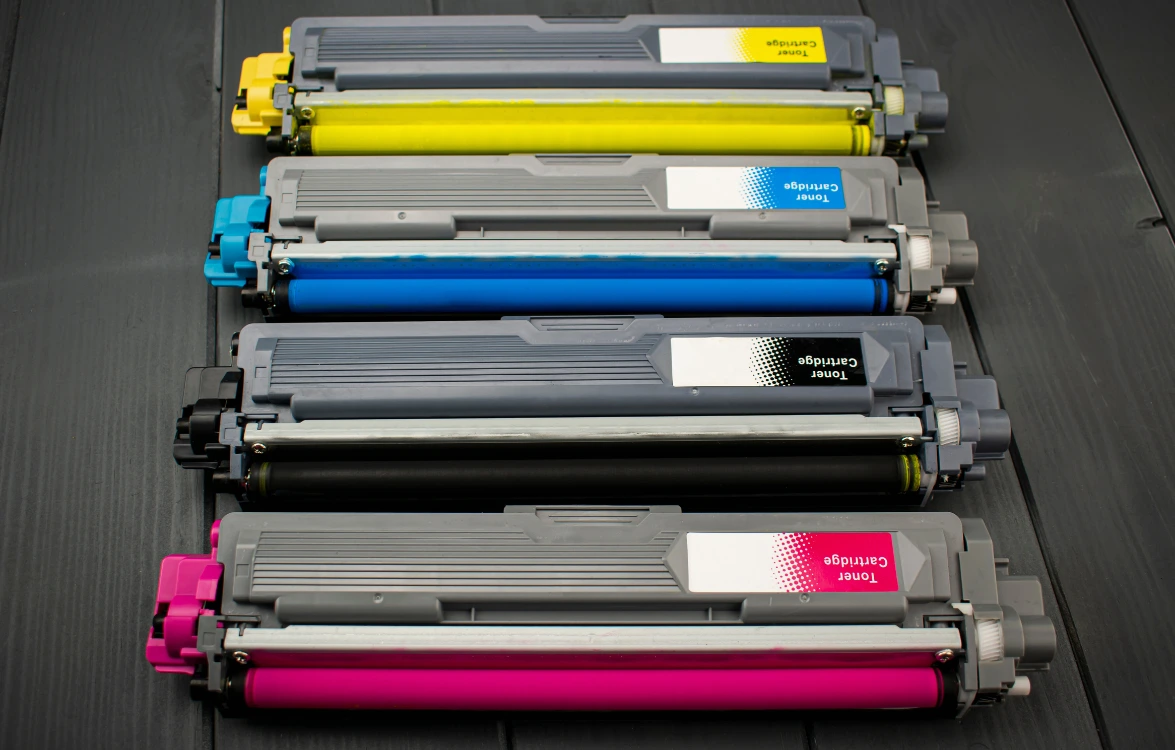 Četiri tonera u različitoj boji na crnoj površini