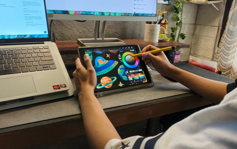 Osoba koristi digitalnu olovku na prijenosnom monitoru osjetljivom na dodir za grafički dizajn uz prijenosno računalo.