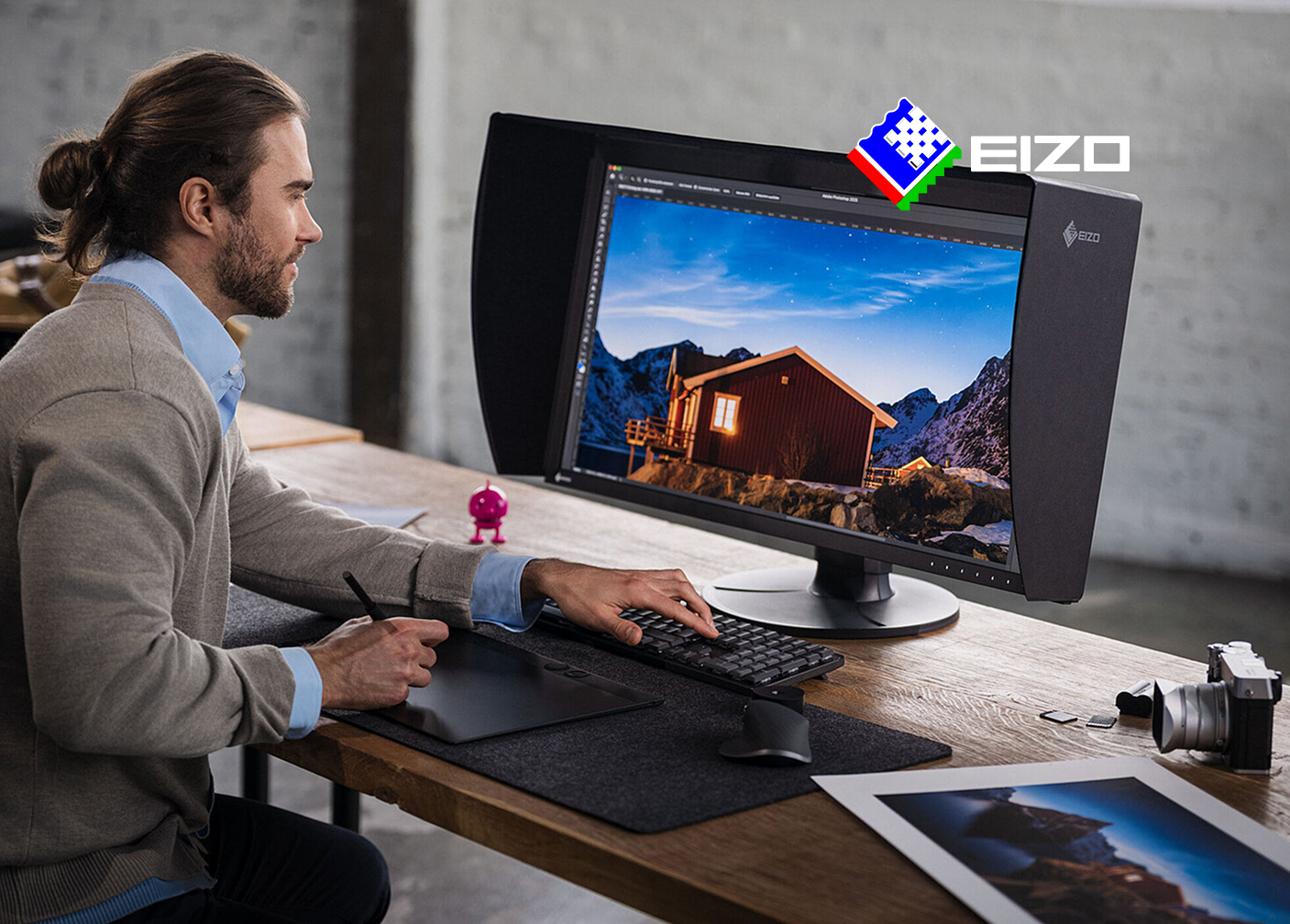 Čovjek koji sjedi za računalom i koristi EIZO profesionalni monitor sa sjenilom.